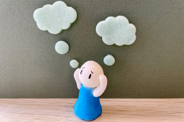 悩んで思考がもやもやしている人の画像