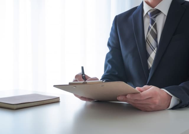 メモを取るビジネスマンの画像