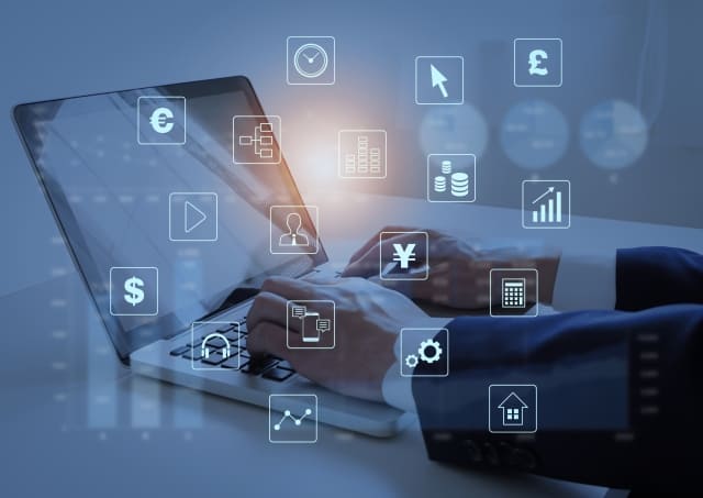 パソコン操作するビジネスマンとアイコンの画像