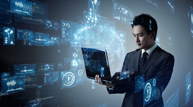 ノートパソコンに向き合うビジネスマンの画像