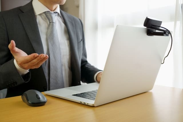 ビデオ通話をするスーツの男性の画像